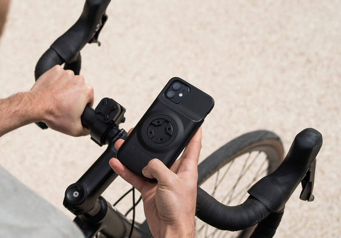 A cyclist wireless charging his phone using the Stride Charge Case